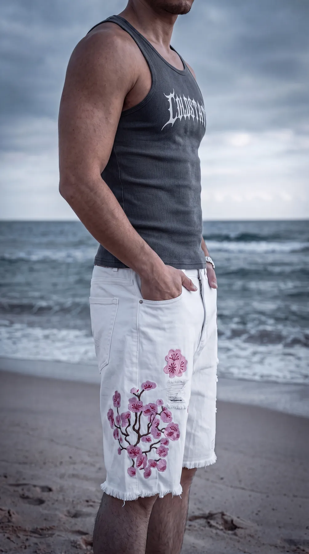 Close crop of the proposed Drop 01 tank and white embroidered shorts by the sea